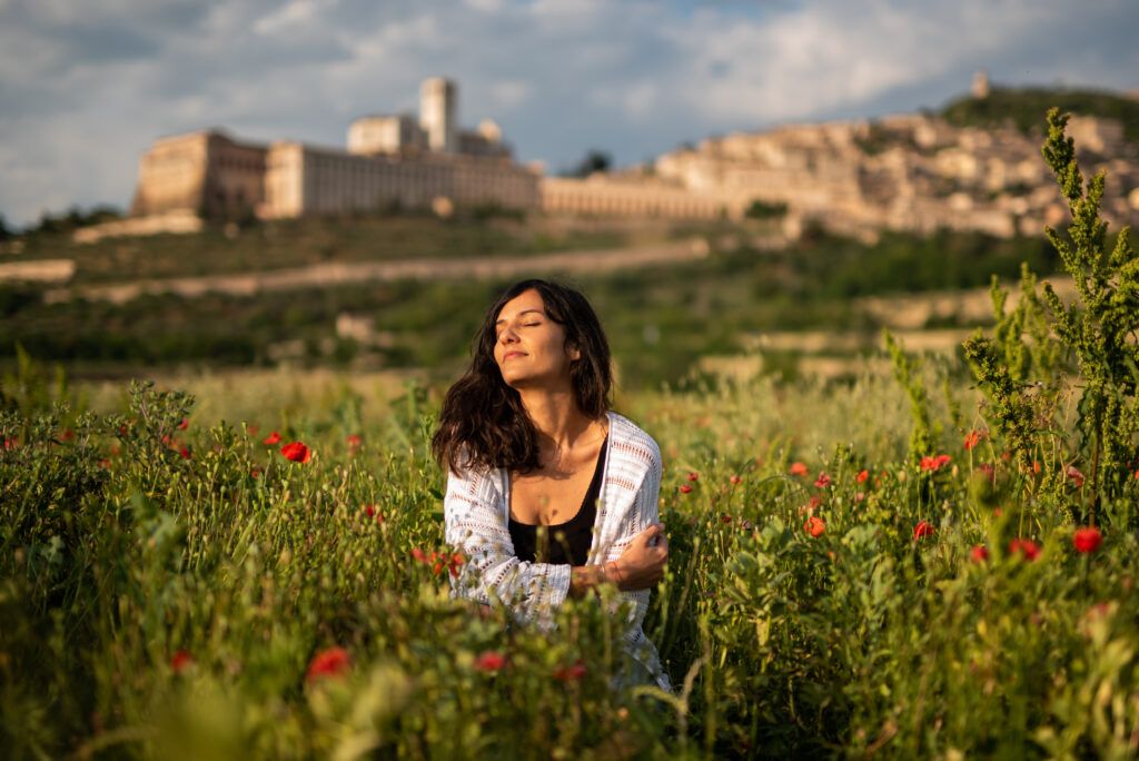 freelance che sta in un campo di papaveri a occhi chiusi