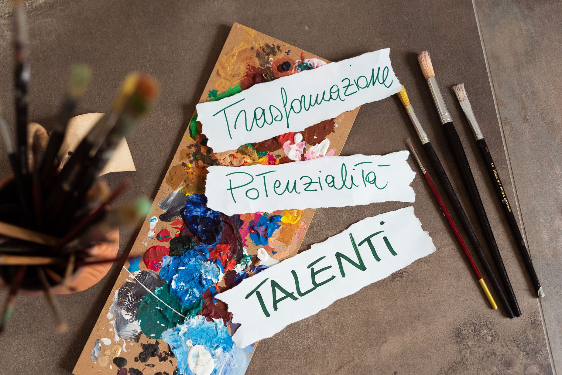 le parole trasformazione potenzialità e talenti scritte in verde su fogli di carta per terra