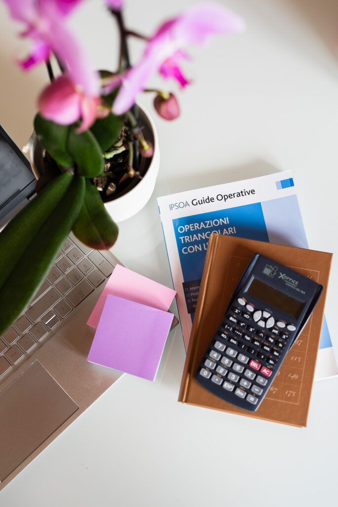 dettaglio di libri di matematica sopra la scrivania e orchidea rosa
