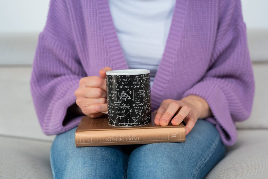 dettaglio mani e tazza con libri