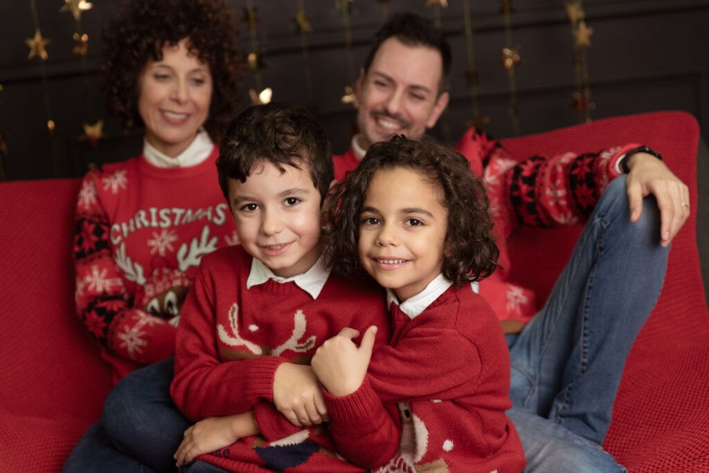 fotografia di famiglia durante shooting natalizio con outfit natalizi